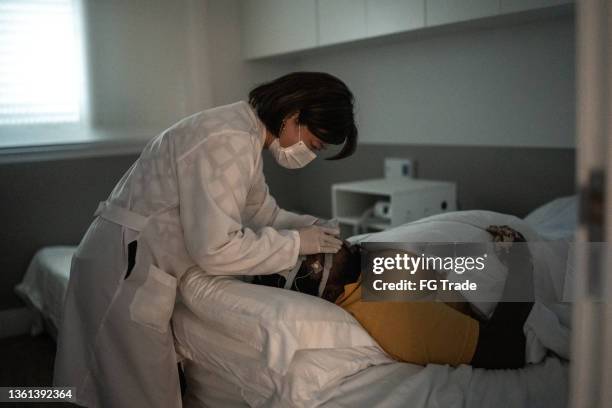 doctor placing electrodes on patient's head for a medical exam - wearing protective face mask - neurologist stock pictures, royalty-free photos & images