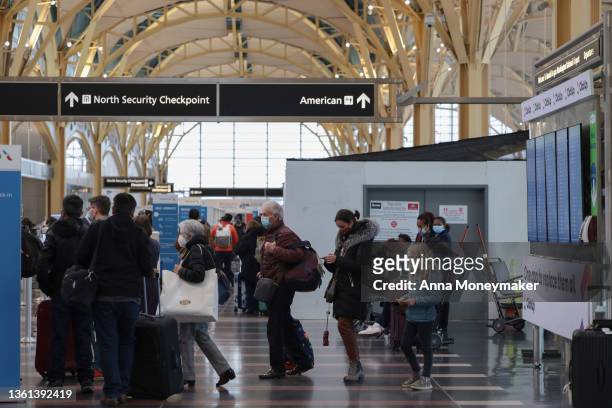 Passengers walk through the departure terminal at the Ronald Reagan Washington National Airport on December 27, 2021 in Arlington, Virginia....