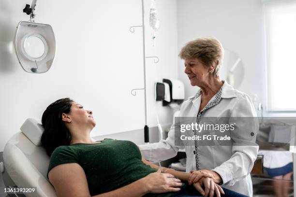 arzt im gespräch mit einem patienten in einer medizinischen klinik - preparing drug in hospital nurse stock-fotos und bilder