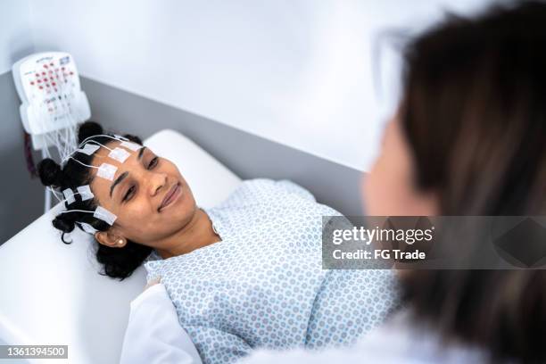 doctor talking to patient's head before a polysomnography (sleep study) - neurologist stock pictures, royalty-free photos & images