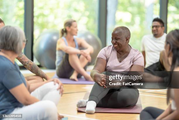 yoga class attendees get to know each other - yoga group stock pictures, royalty-free photos & images