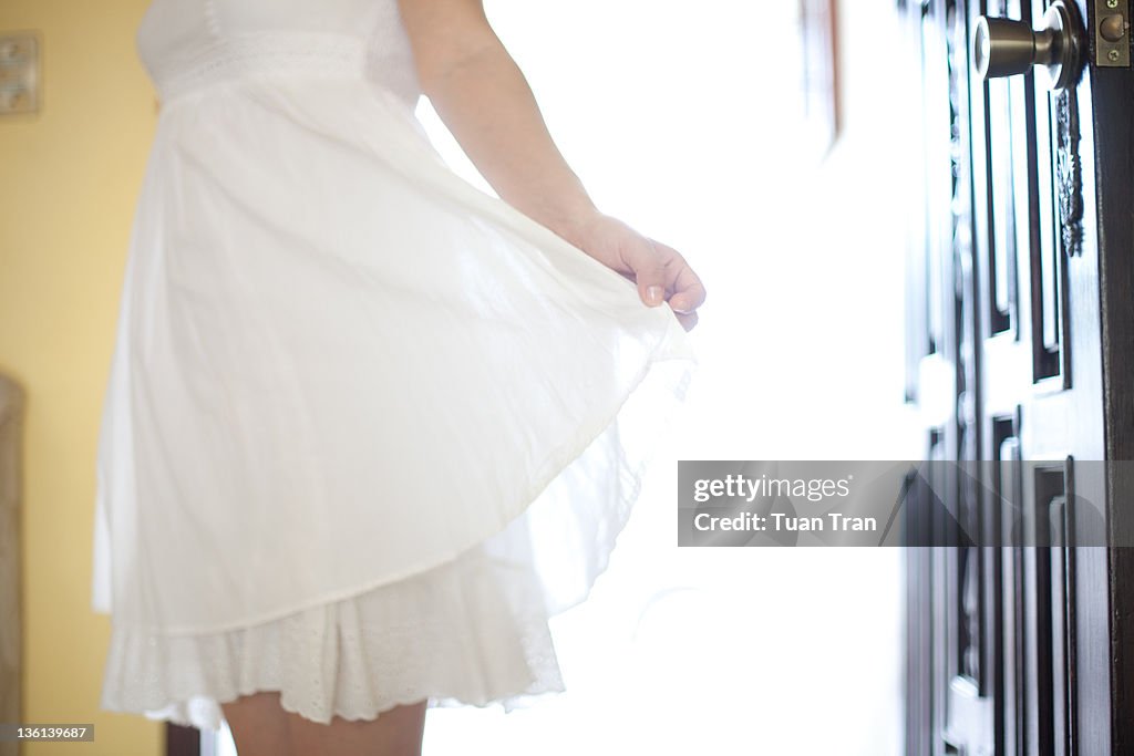 Girl holding one side of her dress up