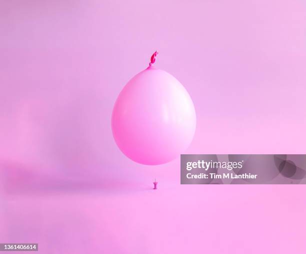 pink balloon floating over a pink pin - balloon burst stock pictures, royalty-free photos & images