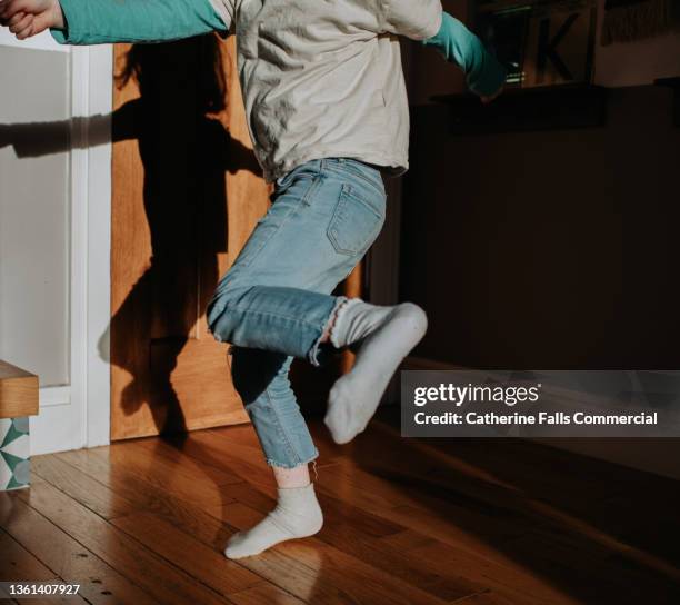 a child performs a kick mid-air - pies bailando fotografías e imágenes de stock