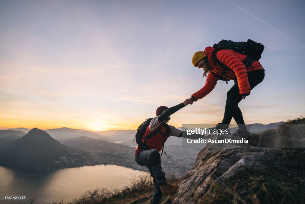 Hiking couple climb up mountain ridge