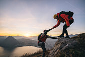 Hiking couple climb up mountain ridge