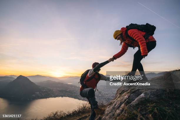 hiking couple climb up mountain ridge - top garment stock pictures, royalty-free photos & images