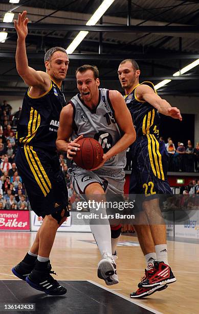 Guido Gruenheid of Artland is challenged by Sven Schultze and Marko Simonovic of Berlin during the Beko Basketball Bundesliga match between Artland...