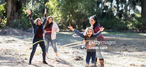 フープで遊んで公園で家族とヒスパニックの女の子 - aunt ストックフォトと画像