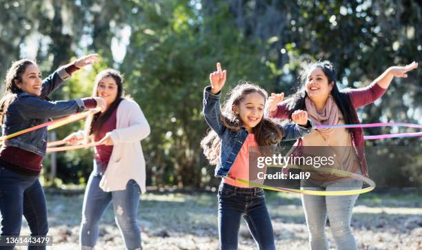 hispanic girl with family at park playing with hoops - hooping stock pictures, royalty-free photos & images