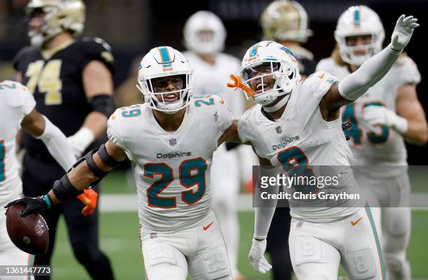 Brandon Jones of the Miami Dolphins celebrates getting an interception with teammate Jevon Holland in the fourth quarter of the game against the New...