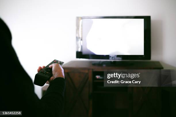 woman changes tv channel with remote control - alter tv stock pictures, royalty-free photos & images