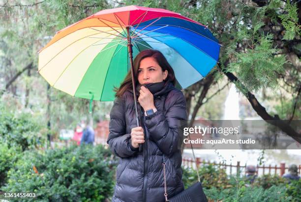frau fühlt sich am regnerischen tag kalt - female with umbrella stock-fotos und bilder
