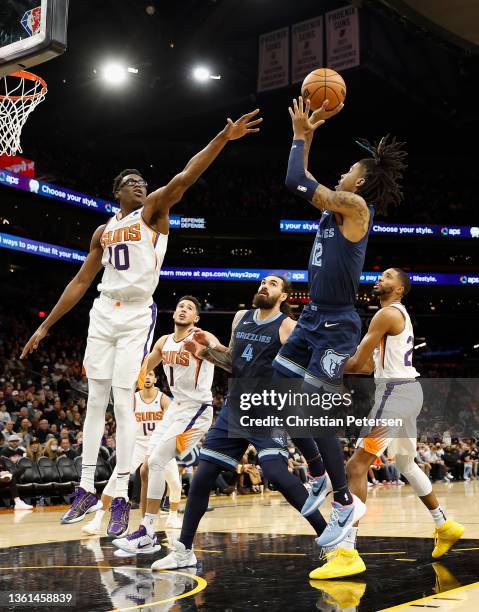 Ja Morant of the Memphis Grizzlies attempts a shot over Jalen Smith of the Phoenix Suns during the second half of the NBA game at Footprint Center on...