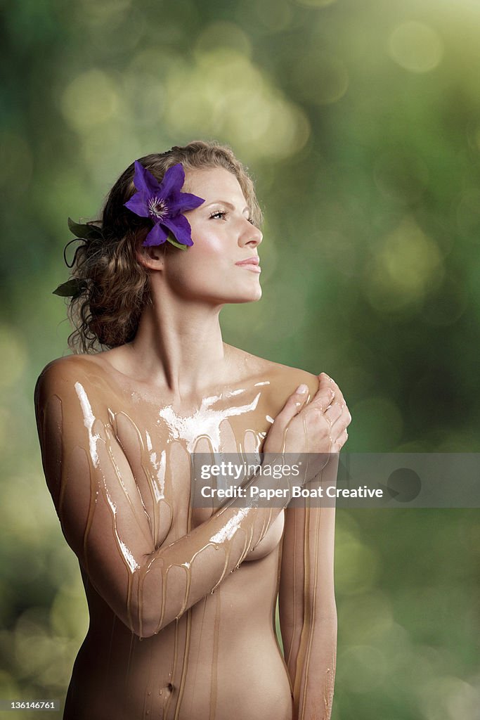 Young woman with honey poured over her body