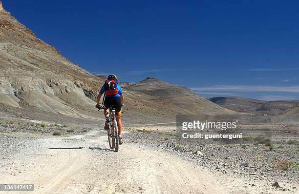 hembra mountainbiker en las montañas del desierto de marruecos - montañas atlas fotografías e imágenes de stock