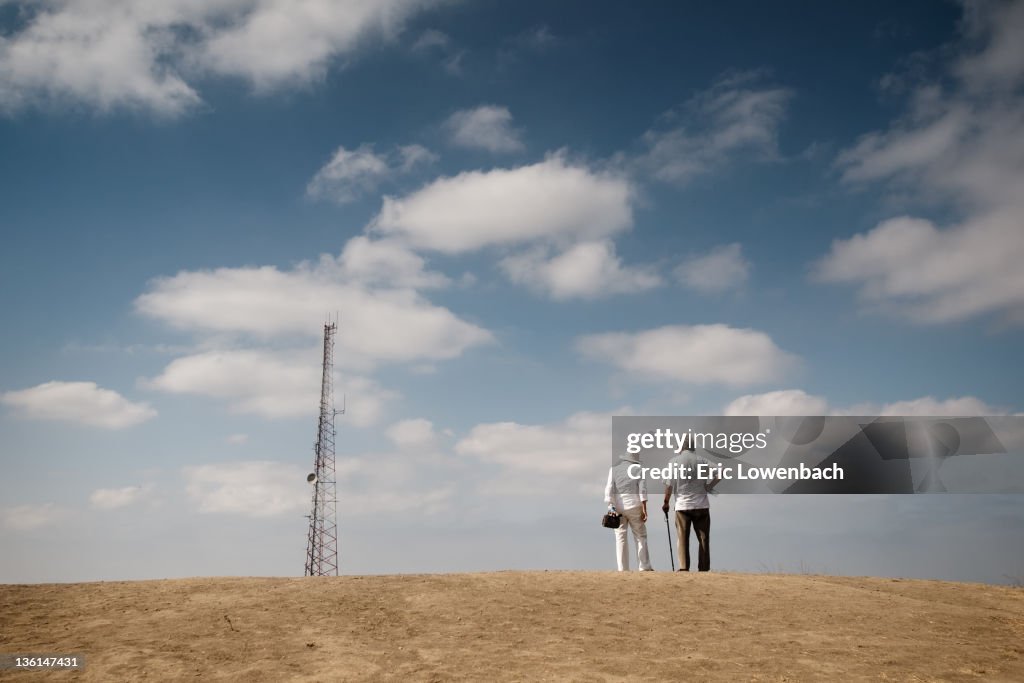 Couple looking at cell phone tower