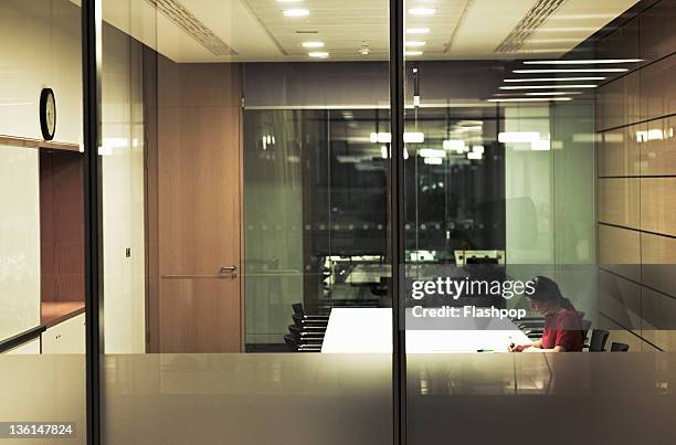 business woman working in boardroom - working overtime stock pictures, royalty-free photos & images