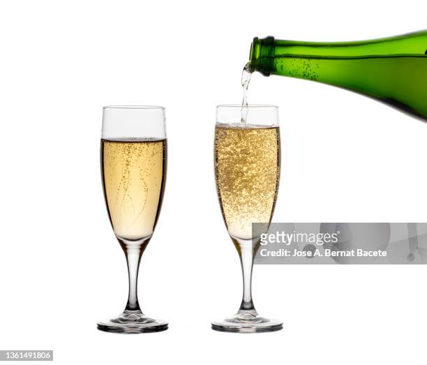 bottle filling two glasses of champagne on a white background. - champagner gläser mit flasche unscharfer hintergrund stock-fotos und bilder