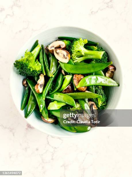 steamed vegetables (broccoli, and sugar snap peas) with mushrooms in a bowl on white background - white mushroom ストックフォトと画像