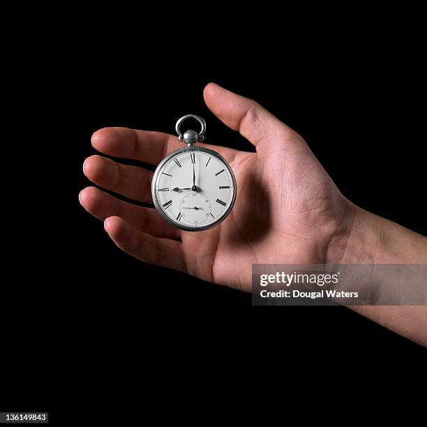 hand grasping pocket watch. - pocket watch stock pictures, royalty-free photos & images