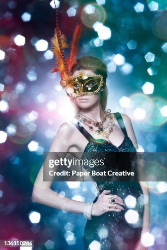 Lady wearing a golden feather mask in a party Lady wearing a golden feather mask in a party