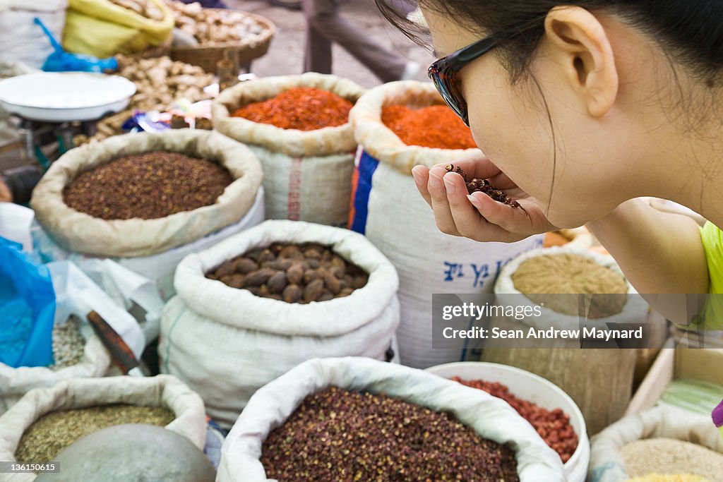 Woman smelling spices at market