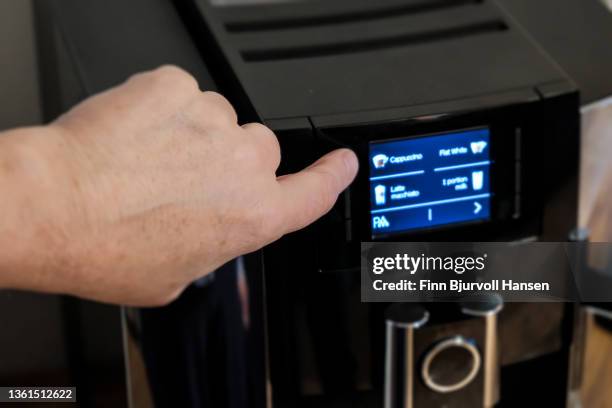 fingerpushing a button on a coffee machine - coffee machine stockfoto's en -beelden