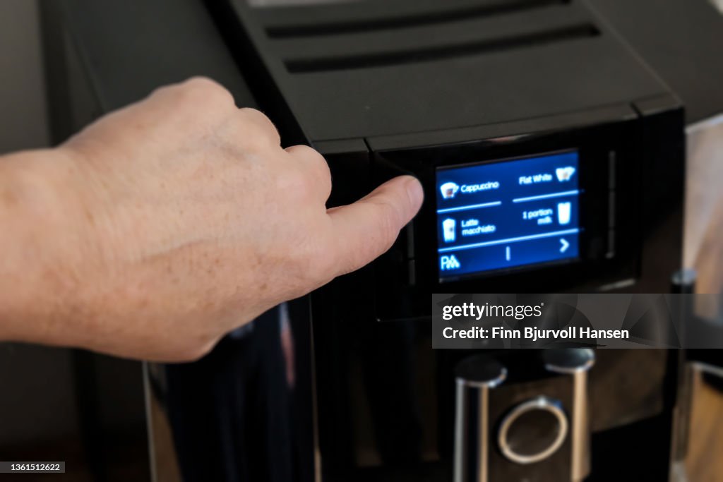 Fingerpushing a button on a coffee machine