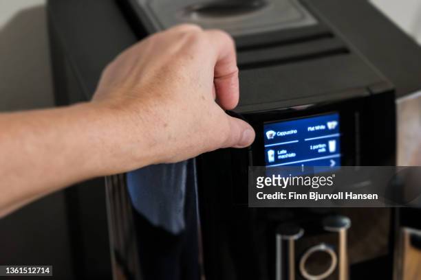 thumb pushing a button on a coffee machine - finn bjurvoll stock pictures, royalty-free photos & images