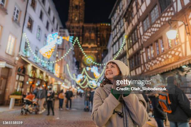 frau unter menschenmassen auf dem weihnachtsmarkt in straßburg - dorffest stock-fotos und bilder