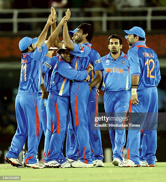 Munaf Patel of India celebrates with teammates after taking the wicket of Pakistani batsman Abdul Razzaq during the 2011 ICC World Cup semi-final...