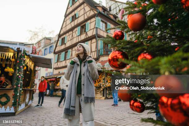 woman walking near the christmas tree  in city centre - christmas market decoration stockfoto's en -beelden