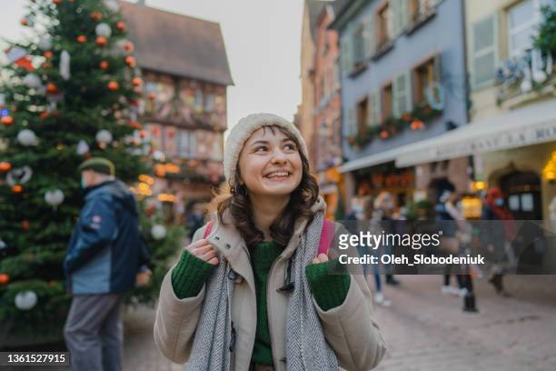 woman walking on christmas market in colmar - strasbourg winter stock pictures, royalty-free photos & images