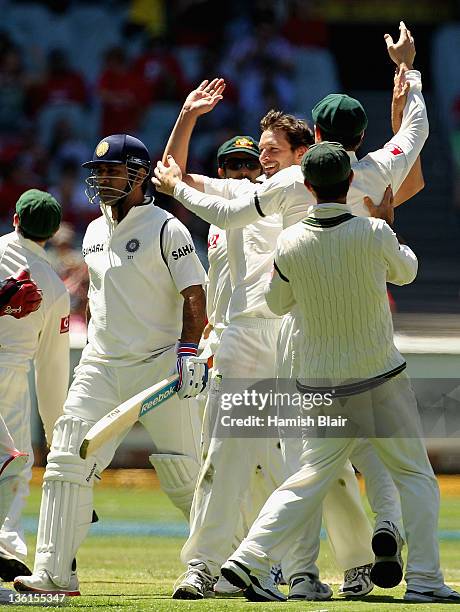 Ben Hilfenhaus of Australia celebrates with team mates after taking the wicket of MS Dhoni of India during day three of the First Test match between...