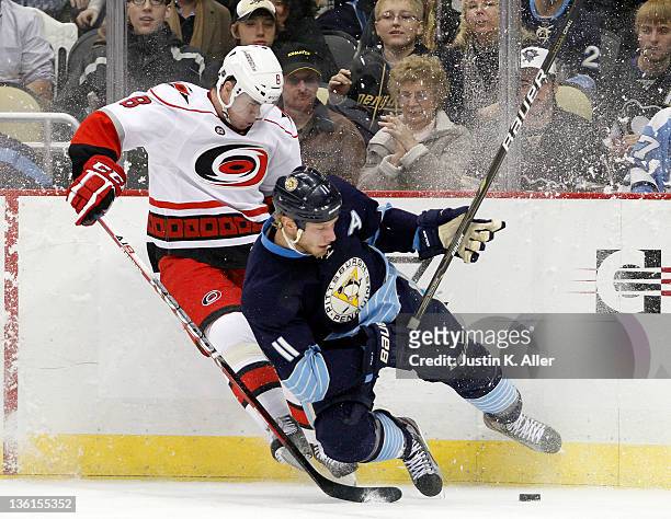 Jordan Staal of the Pittsburgh Penguins and Jaroslav Spacek of the Carolina Hurricanes battle for a puck in the corner during the game at Consol...