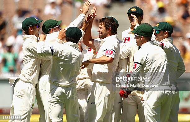 Ben Hilfenhaus of Australia is congratulated by teammates after taking the wicket of MS Dohni of India during day three of the First Test match...