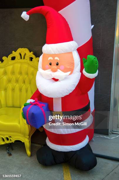 inflatable waving santa claus figure next to an outdoor christmas photo booth - inflatable santa stock pictures, royalty-free photos & images