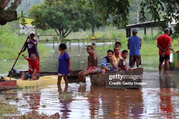 Villagers remain in boats in the flooded roads of their town on December 28, 2021 in Ilheus, Brazil. Floods caused by heavy rains are affecting 40...
