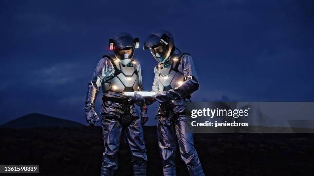 selfie out of this world. astronauts in futuristic suits taking photo and setting the light - movie poster bildbanksfoton och bilder
