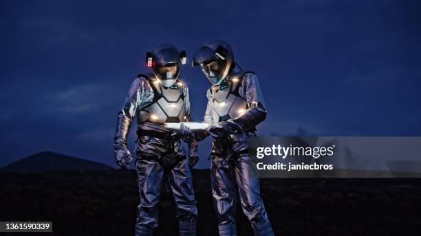 selfie out of this world. astronauts in futuristic suits taking photo and setting the light - astronaut bildbanksfoton och bilder