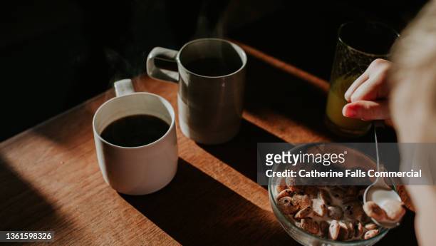 two cups of coffee on a wooden table with a bowl of breakfast cereal - americano photos et images de collection