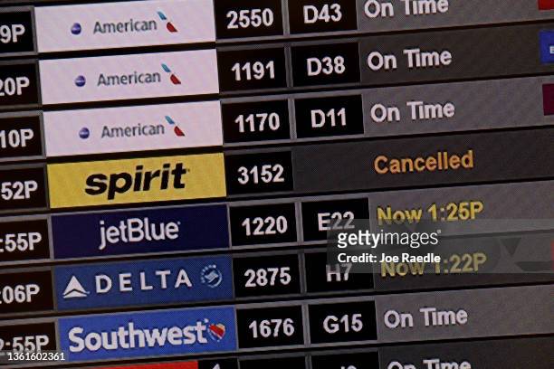 Spirit airlines flight is shown as cancelled on the flight information board at Miami International Airport on December 28, 2021 in Miami, Florida....