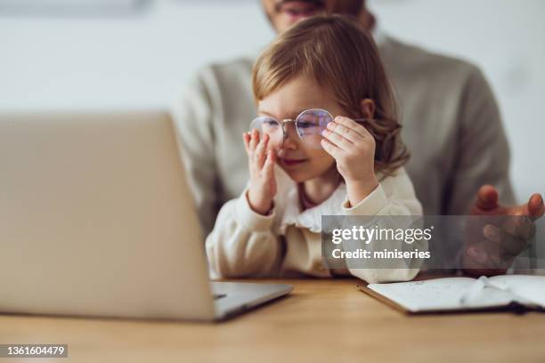 little girl helping her dad with work - facial expression girl office stock pictures, royalty-free photos & images