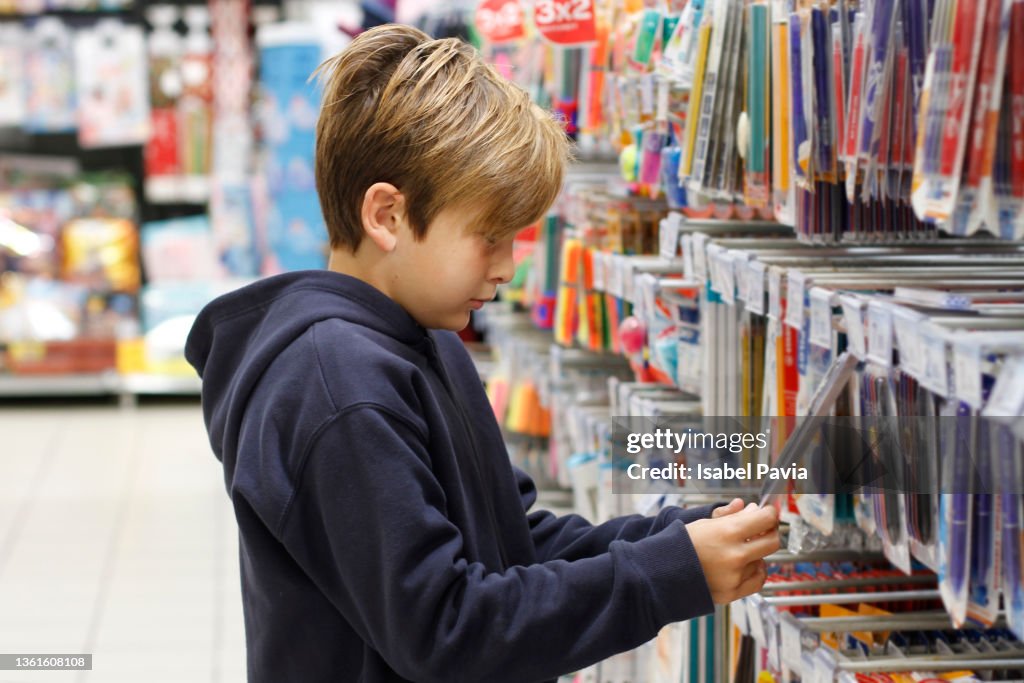 Boy shopping for school supplies at stationery