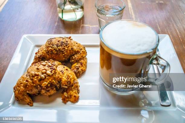 medialunas integrales y taza de café con leche (latte) - cafe taza bildbanksfoton och bilder