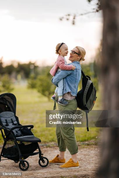 mother and daughter: a walk in the park - baby pram in the park bildbanksfoton och bilder