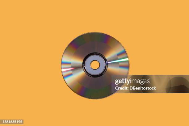 silver compact disc on yellow background. music, storage, dating and retro vintage concept. - colorful cd stock pictures, royalty-free photos & images