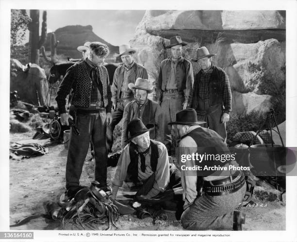 Walter Brennan, leader of the bandits, gets a farewell note from an unwilling member, delivered by his henchmen, Joe Sawyer, in a scene from the film...