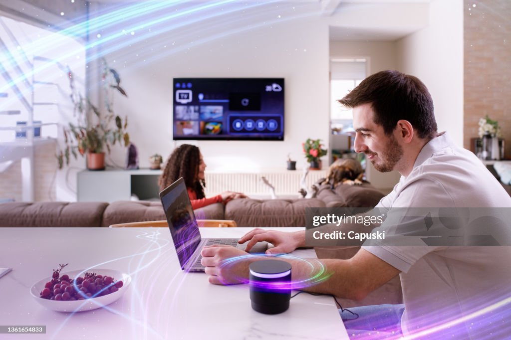 Pareja usando un altavoz inteligente mientras realiza otras tareas cotidianas